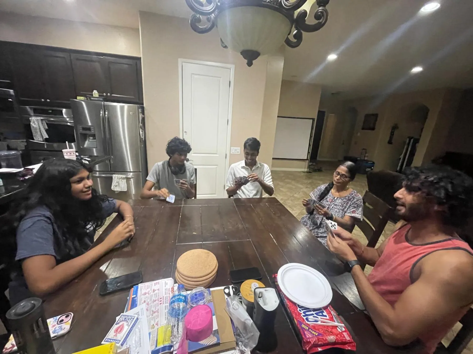 Family sitting around a dining table playing cards