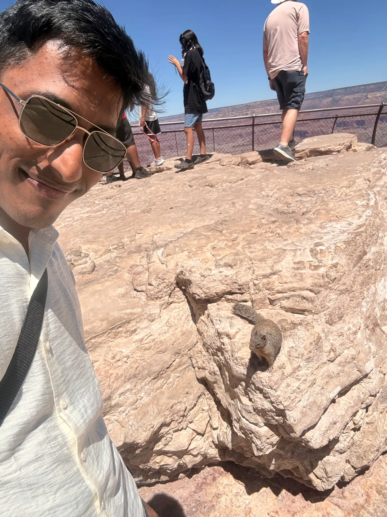 Selfie at the Grand Canyon rim with a squirrel standing on the rock beside me